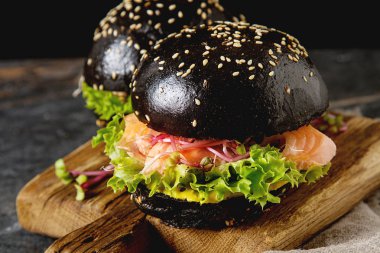 Somon Balık, marul, hardal ile siyah burger. Koyu arka plan