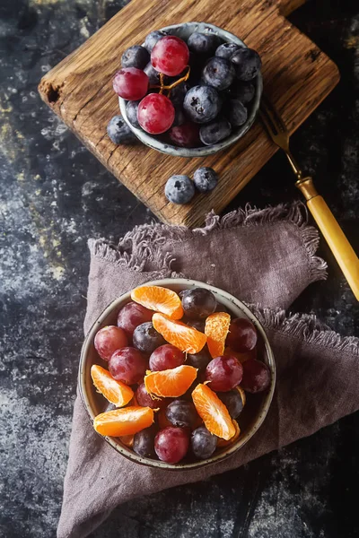 Mandarin, üzüm, yaban mersini meyve salatası ile plaka. Lezzetli 