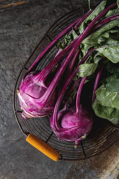 Yeşil yaprakları ile olgun mor şalgam. Gri taş arka plan.