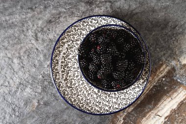 BlackBerry bir seramik tabak içinde. Koyu arka plan. Tatlı berry.