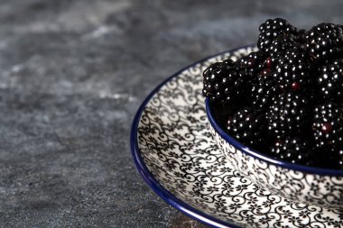 BlackBerry bir seramik tabak içinde. Koyu arka plan. Tatlı berry.