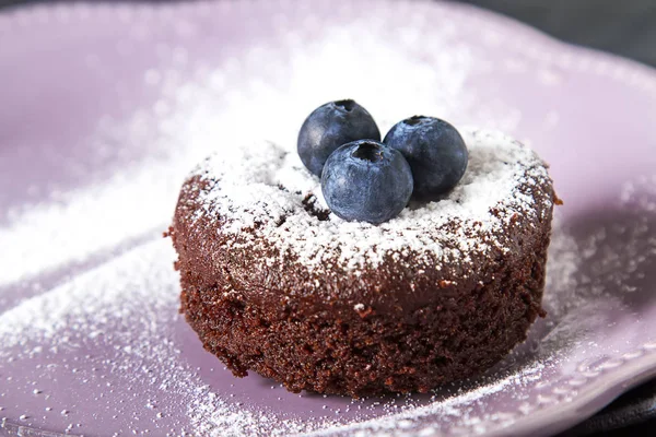 Brownie s borůvkami a moučkového cukru na keramické desce. — Stock fotografie