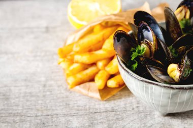 Midye otlar limon ve patates kızartması bir wh üzerinde bir kase ile