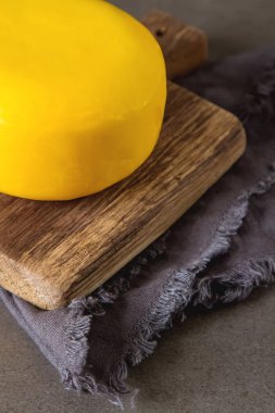 Yuvarlak gouda peyniri. Koyu arka plan.