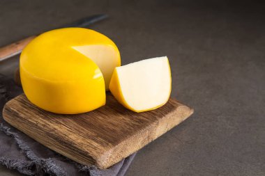 Round gouda cheese. Dark background. clipart