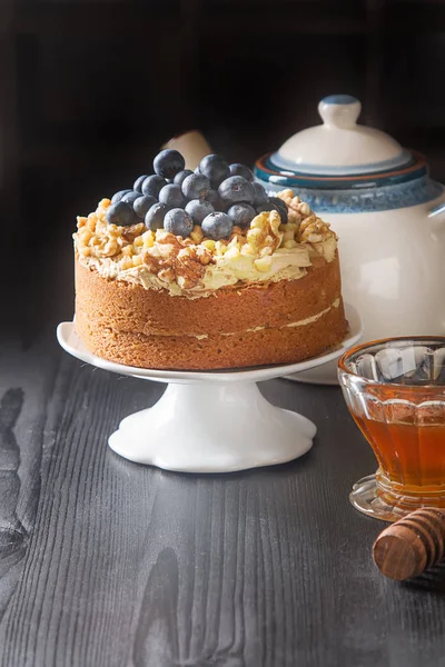 Homemade cake with nuts and blueberries. A cup of tea, honey and — Stock Photo, Image