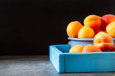 Olgun kayısı bir kase. Koyu arka plan. Bir vegan yemek ve bir