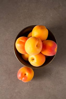 Olgun kayısı bir kase. Koyu arka plan. Bir vegan yemek ve bir