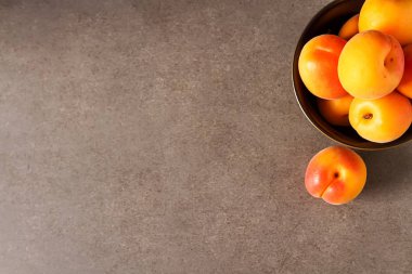 Olgun kayısı bir kase. Koyu arka plan. Bir vegan yemek ve bir