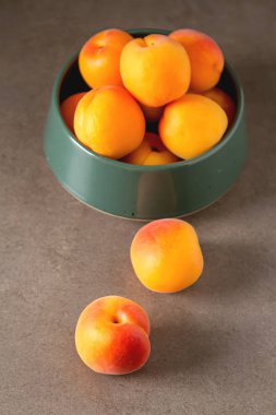 Olgun kayısı bir kase. Koyu arka plan. Bir vegan yemek ve bir