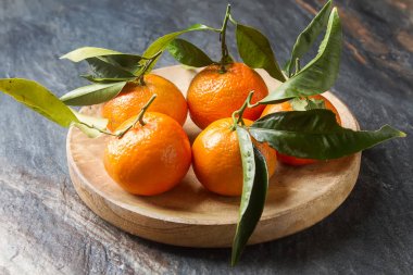 Turuncu olgun mandalina ile yeşil dalı üzerinde bırakır. Geri gri