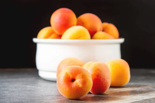 Reife Aprikosen in einer Schüssel. dunkler Hintergrund. Nahrung für einen Veganer und einen — Stockfoto