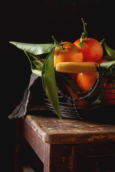 Naranja mandarina madura en la rama verde con hojas. Madera oscura —  Fotos de Stock