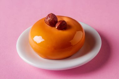 Trendy mousse kek ayna sır ile dekore edilmiştir. Pembe bir arka plan.