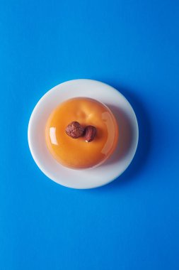 Trendy mousse kek ayna sır ile dekore edilmiştir. Mavi arka plan.