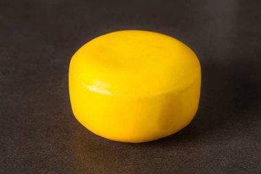 Yuvarlak gouda peyniri. Koyu arka plan.