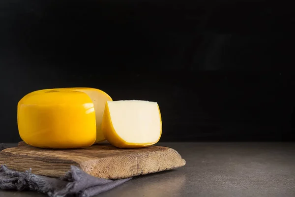 Ronde Goudse kaas. Donkere achtergrond. — Stockfoto