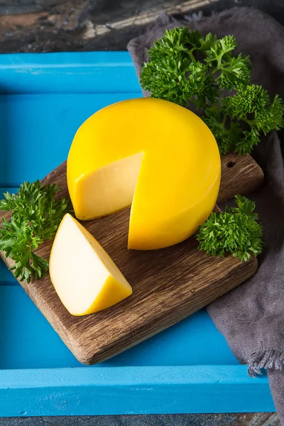 Ronde Goudse kaas met peterselie. Donkere achtergrond. — Stockfoto