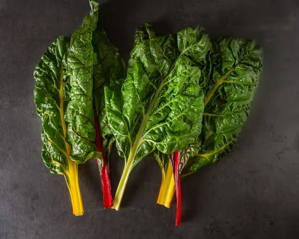 Acelga arco iris, alimentación colorida y dietas saludables. Fondo oscuro. —  Fotos de Stock