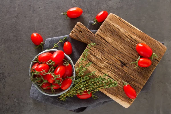 Los tomates rojos pequeños de guinda en la minsk cerámica de época. Respaldo oscuro — Foto de Stock