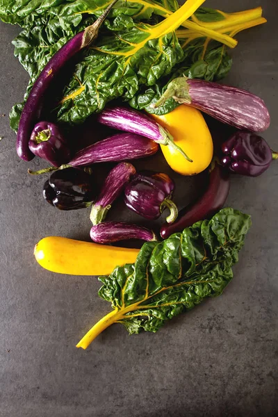 Small eggplant, yellow zucchini, chard and purple pepper. Dark b — Stock Photo, Image