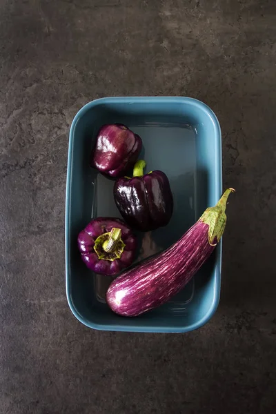 Small eggplant and purple pepper. Dark background. Vegetarian fo — Stock Photo, Image