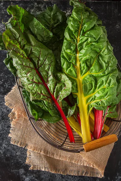Acelga arco iris, alimentación colorida y dietas saludables. Fondo oscuro. —  Fotos de Stock