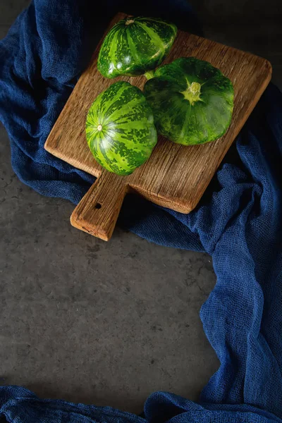 Sağlıklı ve lezzetli bir ahşap tahta üzerinde yeşil patissons... karanlık b
