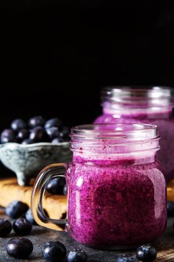 Taze sulu blueberry smoothies cam. Basit arka plan.