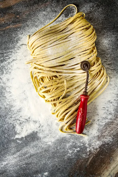 Un ile İtalyan ev yapımı tagliatelle. Koyu arka plan.