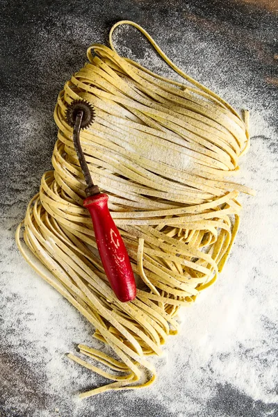 Un ile İtalyan ev yapımı tagliatelle. Koyu arka plan.
