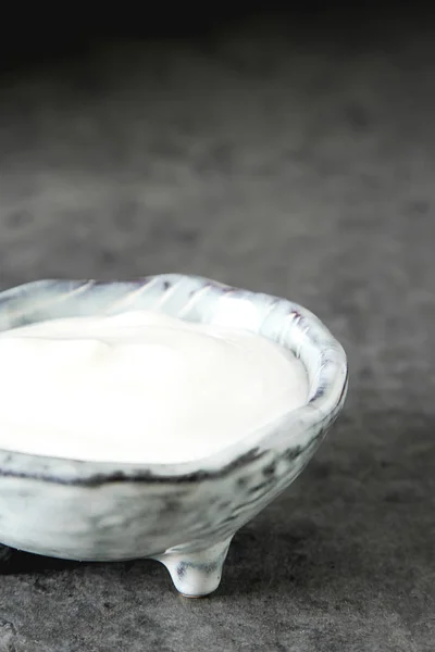 Σπιτική κρέμα γάλακτος σε ένα κεραμικό μπολ. Σκούρο φόντο. — Φωτογραφία Αρχείου