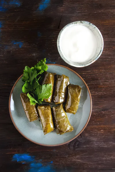 Deliciosas hojas de vid rellenas con arroz y carne con crema agria —  Fotos de Stock