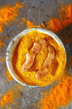 Zerdeçal tozu ve taze zerdeçal. Koyu arka plan. T için alan