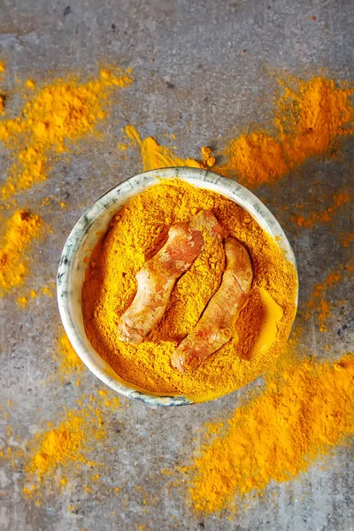 Zerdeçal tozu ve taze zerdeçal. Koyu arka plan. T için alan