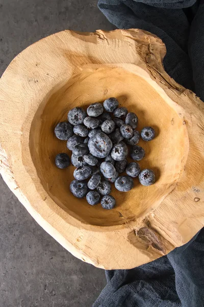 Ripe juicy blueberries in a wooden bowl. Dark background. Space — Stock Photo, Image