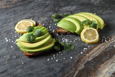 Avokado sandviç taze dilimlenmiş avocad ile yapılan koyu siyah ekmek üzerinde