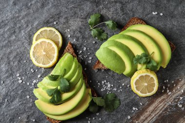Avokado sandviç taze dilimlenmiş avocad ile yapılan koyu siyah ekmek üzerinde