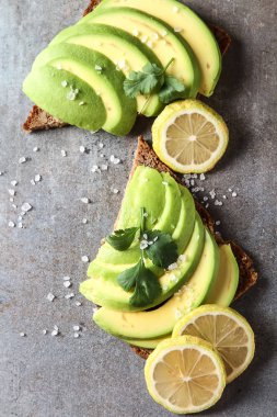 Avokado sandviç taze dilimlenmiş avocad ile yapılan koyu siyah ekmek üzerinde