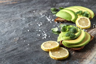 Avokado sandviç taze dilimlenmiş avocad ile yapılan koyu siyah ekmek üzerinde