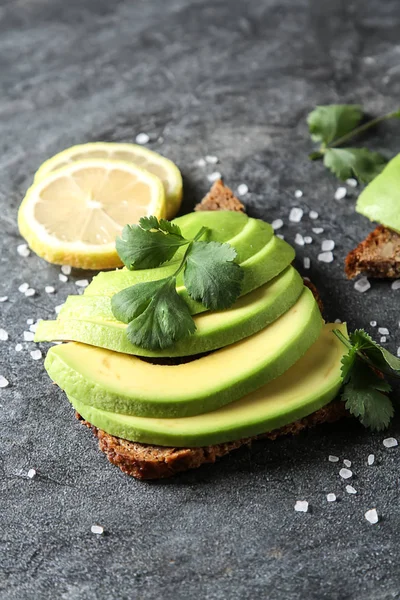 Avokado sandviç taze dilimlenmiş avocad ile yapılan koyu siyah ekmek üzerinde