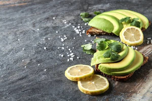Avokado sandviç taze dilimlenmiş avocad ile yapılan koyu siyah ekmek üzerinde