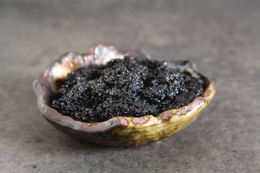Seramik bir kabın içinde siyah mersin balığı havyar. Koyu arka plan.