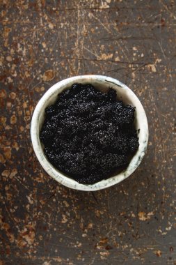 Seramik bir kabın içinde siyah mersin balığı havyar. Koyu arka plan.