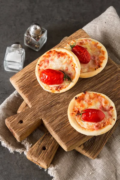 Włoski mini pizzę domowej roboty z serem, pomidory. Ciemny backgrou — Zdjęcie stockowe