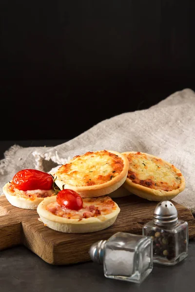 Peynir, İtalyan ev yapımı mini pizza domates. Karanlık backgrou