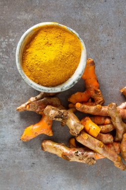 Zerdeçal tozu ve taze zerdeçal. Koyu arka plan. T için alan