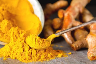 Zerdeçal tozu ve taze zerdeçal. Koyu arka plan. T için alan