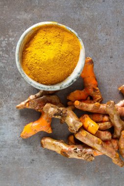 Zerdeçal tozu ve taze zerdeçal. Koyu arka plan. T için alan