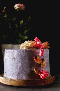 Çikolatalı pasta doğum günü için çiçekli. Koyu arka plan.